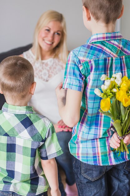 Kinder mit Blumenstrauß zu geben, um ihre Mutter