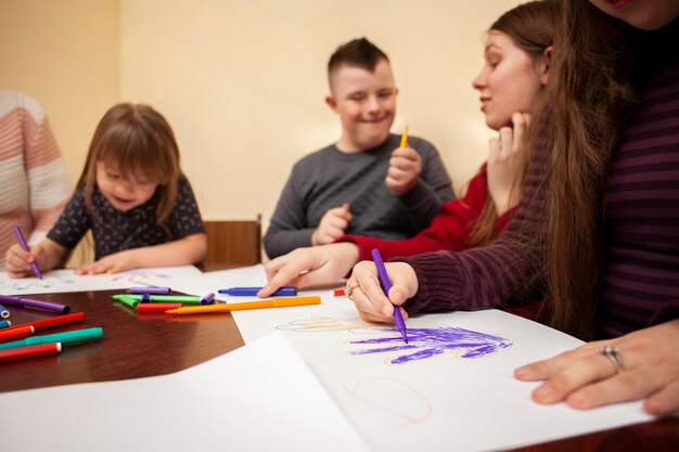 Kinder mit Down-Syndrom zeichnen und haben Spaß