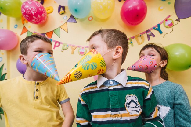 Kinder mit Partyhüten auf Gesichtern