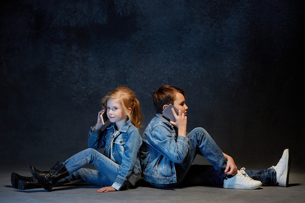 Kinder posieren in Jeans im Sitzen