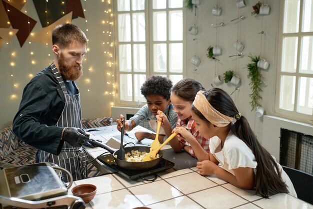 Kinder probieren das essen vom küchenchef