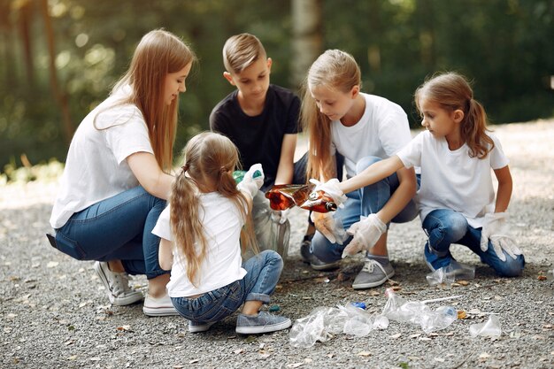 Kinder sammelt Müll in Müllsäcken im Park