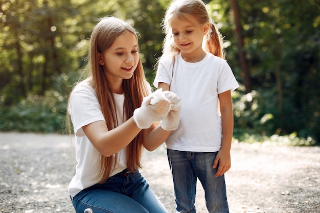 Kinder sammelt Müll in Müllsäcken im Park