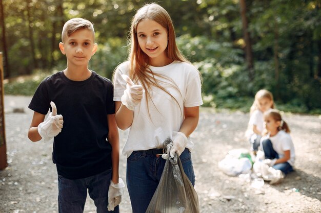 Kinder sammelt Müll in Müllsäcken im Park