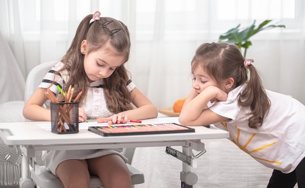 Kinder sitzen am Tisch und machen ihre Hausaufgaben. Kind lernt zu Hause. Heimunterricht.