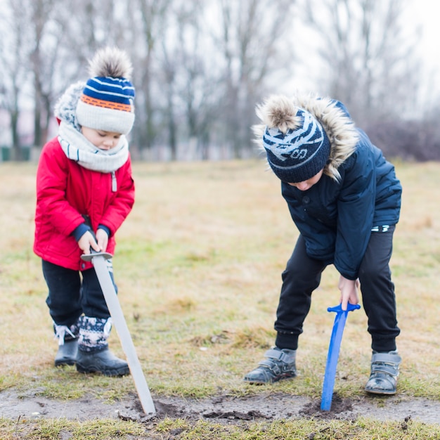 Kinder spielen draußen mit Schlamm