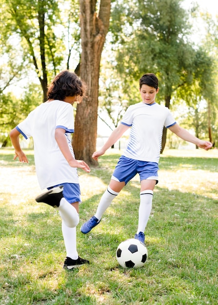 Kinder spielen Fußball im Freien