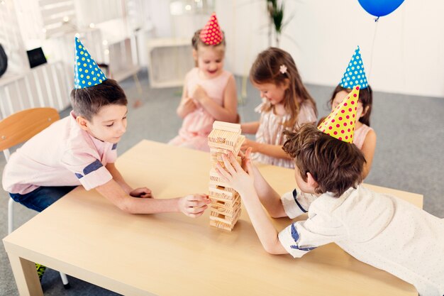 Kinder spielen hölzernes Spiel auf Party