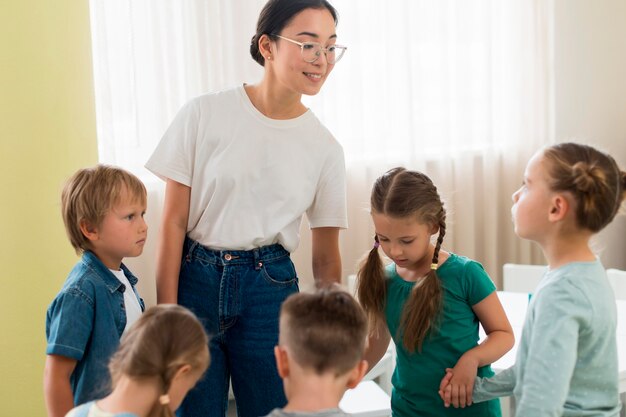 Kinder spielen mit ihrem Lehrer