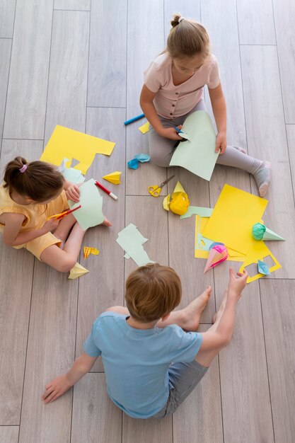 Kinder spielen mit Papier voll Schuss