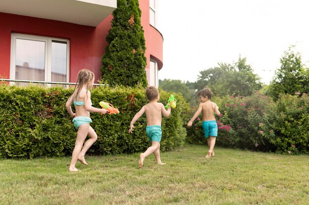 Kinder spielen mit Wasserpistolen