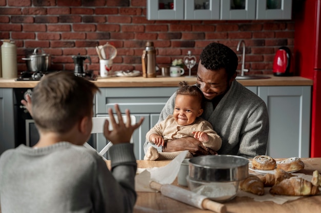 Kinder und Vater am Tisch mittlerer Schuss