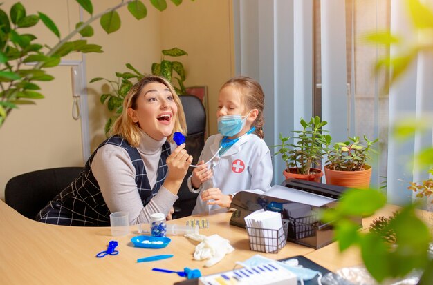 Kinderarzt, der ein Kind in einer komfortablen Arztpraxis untersucht. Konzept für Gesundheitswesen, Kindheit, Medizin, Schutz und Prävention.