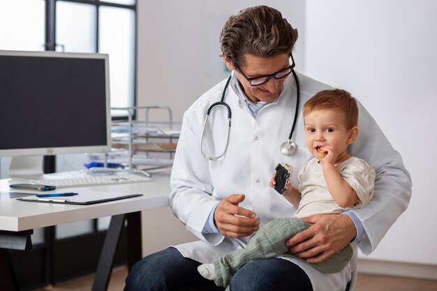Kinderarzt hält Kleinkind für eine Beratung