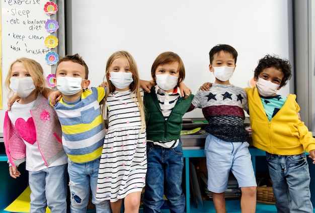 Kindergartenkinder, die Masken in einem Klassenzimmer tragen