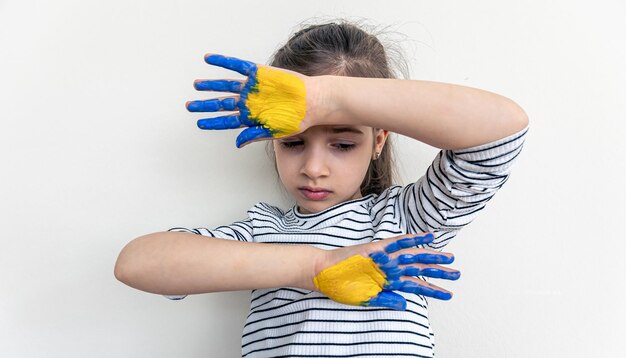 Kinderhände auf Farben der ukrainischen Flagge gemalt