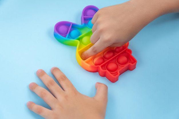 Kinderhand, die mit Pop-It-Spielzeug spielt