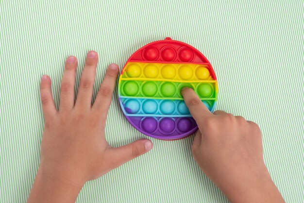 Kinderhand, die mit Pop-It-Spielzeug spielt