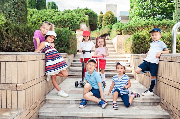 Kindermode-Konzept. Die Gruppe von jugendlichen Jungen und Mädchen, die im Park posieren. Kinder bunte Kleidung, Lebensstil, trendige Farbkonzepte.