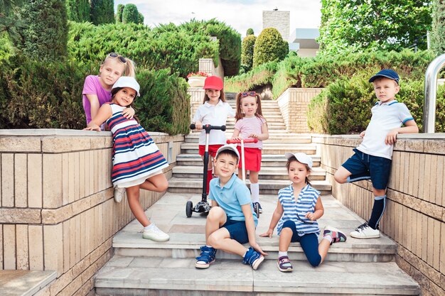 Kindermode-Konzept. Die Gruppe von jugendlichen Jungen und Mädchen, die im Park posieren. Kinder bunte Kleidung, Lebensstil, trendige Farbkonzepte.