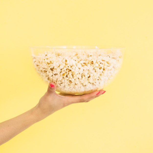 Kostenloses Foto kinokonzept mit der hand, die popcorn hält