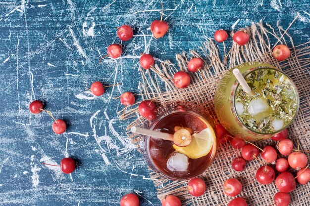 Kirschbeeren mit einer Tasse Getränk auf Blau.