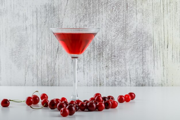 Kirschsaft mit Kirschen in einem Glas auf Weiß