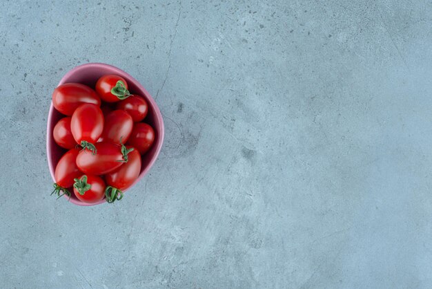 Kirschtomaten in einer Tasse auf Blau.