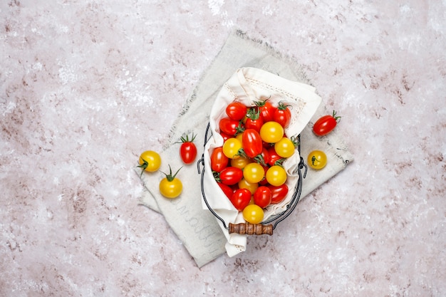 Kirschtomaten von verschiedenen Farb-, Gelben und Rotenkirschtomaten in einem Korb auf hellem Hintergrund