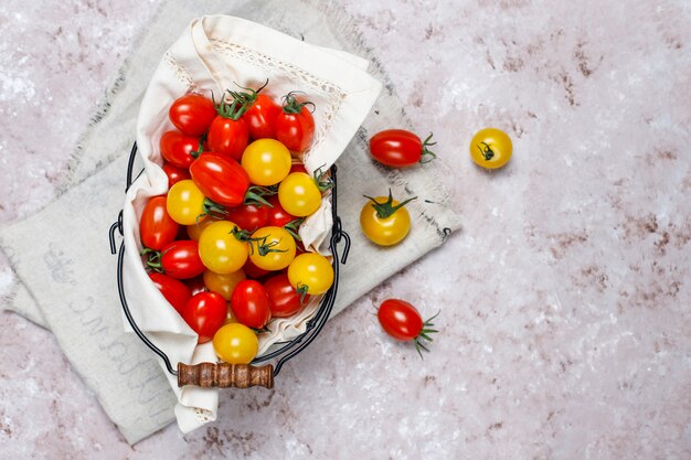 Kirschtomaten von verschiedenen Farb-, Gelben und Rotenkirschtomaten in einem Korb auf hellem Hintergrund