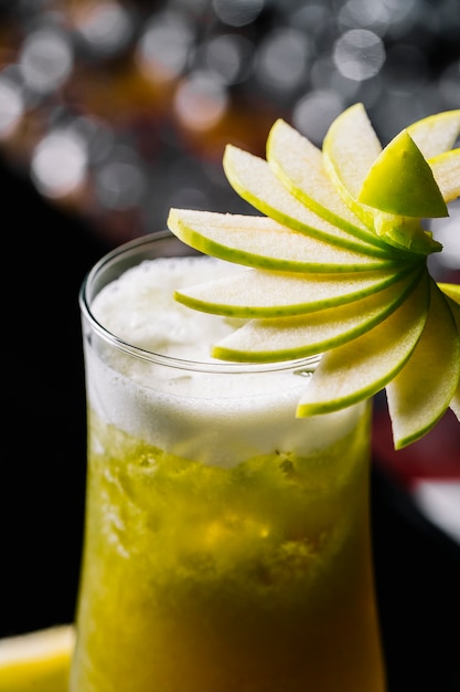 Kiwi-Cocktail von der Seite mit Apfel im Glas