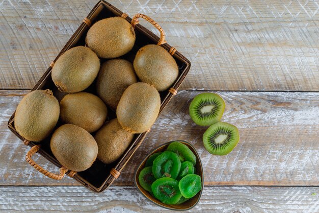 Kiwi in einem Korb mit getrockneten Scheiben lag flach auf einem Holztisch