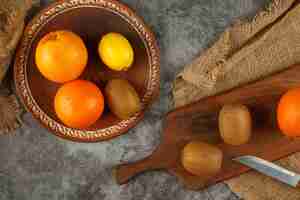 Kostenloses Foto kiwi, orange und zitronen in einer schüssel.