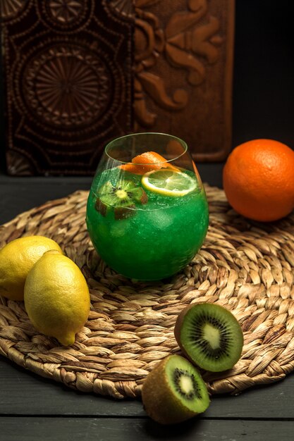 Kiwicocktail mit Kiwi- und Limonscheibe, Orangenschale