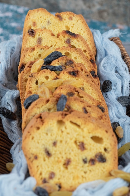 Kostenloses Foto klassische sultaninenkuchenscheiben auf holzkorb auf blauem tuch.