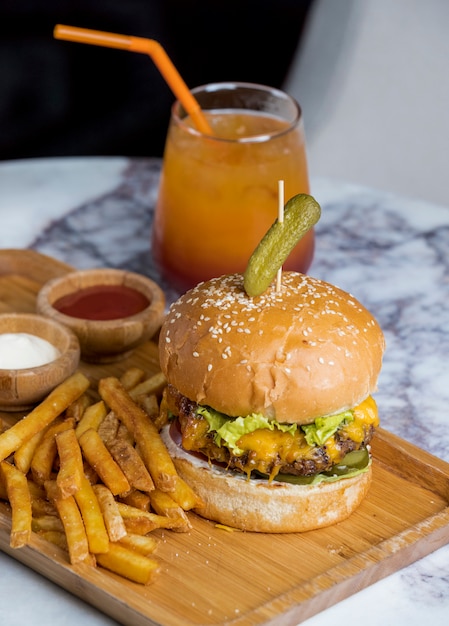 Kostenloses Foto klassischer cheeseburger mit pommes frites und multivitaminsaft