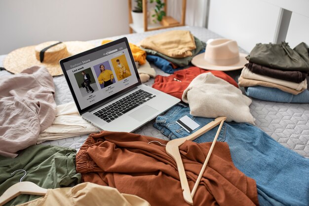 Kleidung und Laptop auf dem hohen Winkel der Bettanordnung