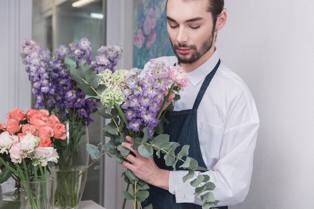 Kleinbetrieb. Männlicher Florist im Blumenladen. Dekorationen und Arrangements machen