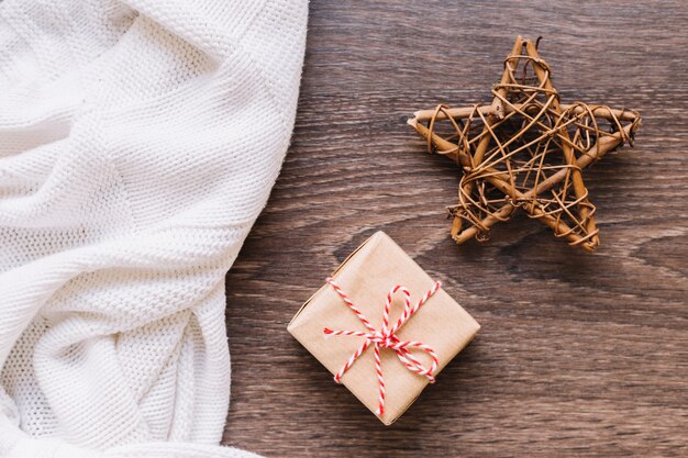 Kleine Geschenkbox mit hölzernem Stern auf Tabelle