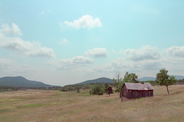 Kleine Holzscheune auf einem großen Feld gebaut