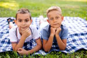 Kostenloses Foto kleine jungen posieren auf einer picknickdecke