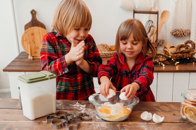 Kleine Kinder der Vorderansicht, die Weihnachtsplätzchen machen