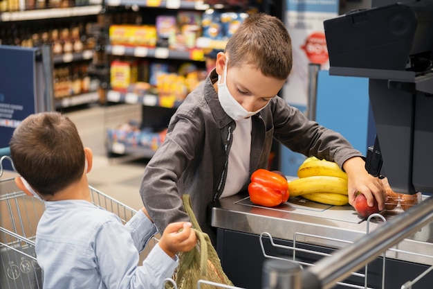 Kleine Kinder kaufen mit Masken ein