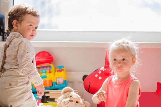 Kostenloses Foto kleine kinder posieren am fenster