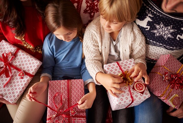 Kleine Kinder sind bereit, Weihnachtsgeschenke zu öffnen