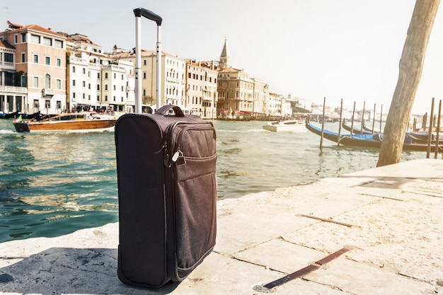 Kleine Koffer auf Reisen Städtischer Hintergrund, Venedig, Italien. Horizontal. Toning Reise Urlaub Konzept.