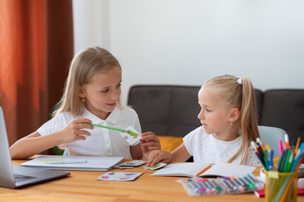 Kleine Mädchen, die zusammen Online-Schule machen