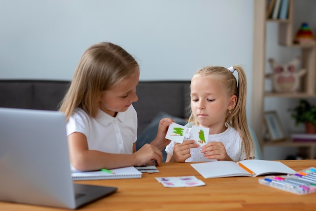 Kleine Mädchen, die zusammen Online-Schule machen