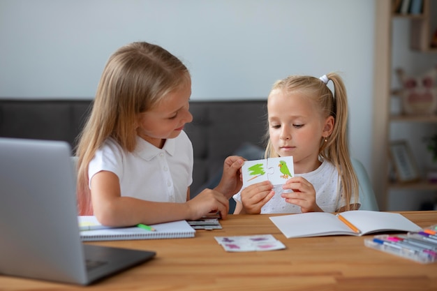 Kostenloses Foto kleine mädchen, die zusammen online-schule machen