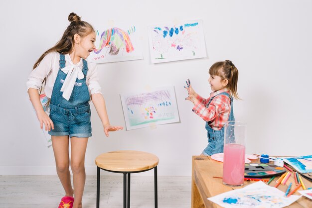 Kleine Mädchen laufen mit gemalten Fingern